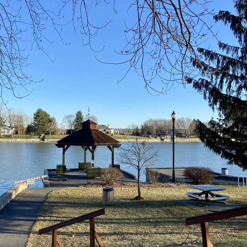 Parc riverain de Saint-Marc-sur-Richelieu : kiosque de bois au bord de la rivière Richelieu, table à pique-nique et clôture basse sous un ciel dégagé